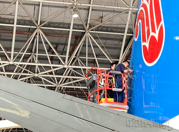图为工作者正站在登高车上检查飞机尾翼。摄影：李春雨_副本.png