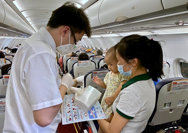 图  8月15日北部湾航空GX8949海口-徐州航班乘务员为旅客服务.jpg