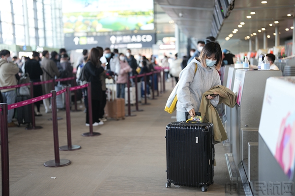 图为旅客完成值机手续办理正式踏上出行之旅