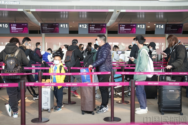 图为春运首日,旅客在上海虹桥机场T2航站楼吉祥航空值机区有序排队办理托运手续