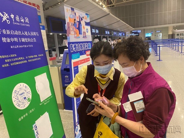 工作人员指导旅客填报出境手续
