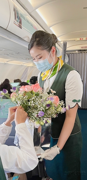 主题航班上,春秋乘务员为旅客送上玫瑰花-春秋航空供图2