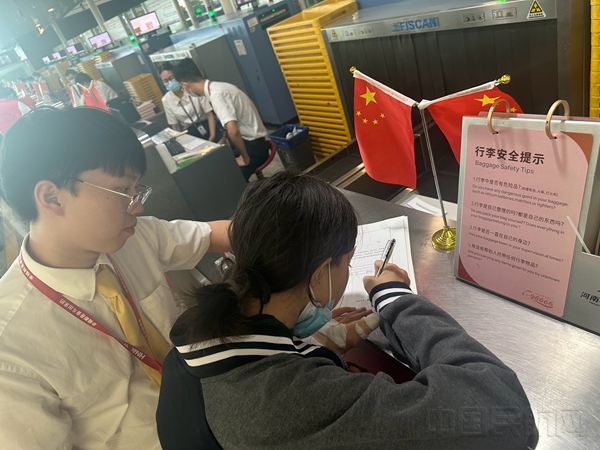附图1:海航工作人员协助小旅客填写乘机信息2