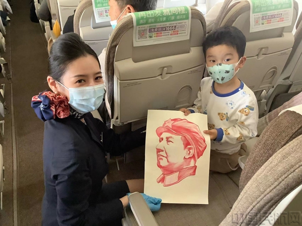 乘务员给小旅客送上自己创作的毛泽东画像-董海燕摄