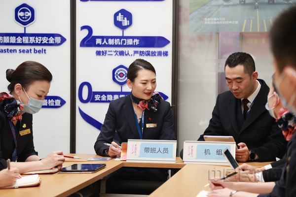Neo 带班乘务长张璇(左二)与机长李晓亮(左三)在航前准备会上-胡夕姮摄05