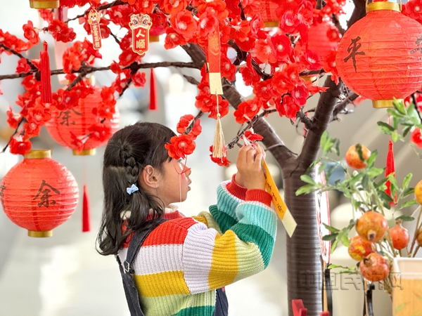 Neo 上海浦东机场南航明珠休息室内,一名小旅客正在将自己的新年愿望悬挂在祈愿树上。朱慧 摄06