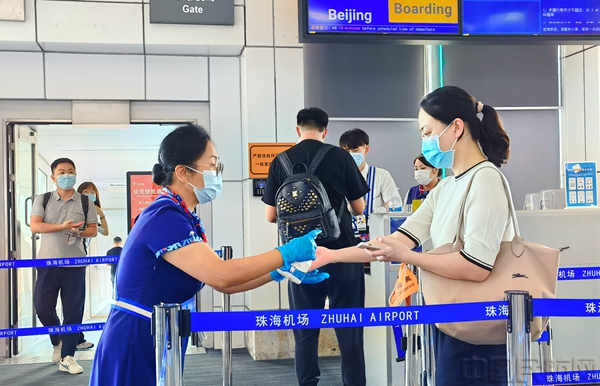 工作人员为登机旅客提供手部消毒服务.jpg