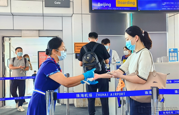 工作人员为登机旅客提供手部消毒服务.jpg 工作人员为登机旅客提供手部消毒服务.jpg